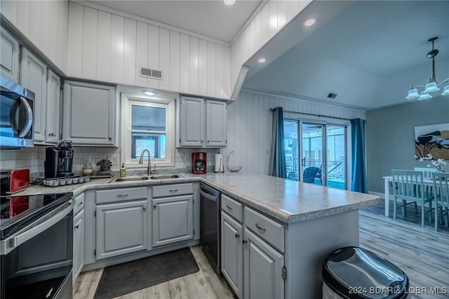 kitchen with decorative backsplash, plenty of natural light, kitchen peninsula, and sink