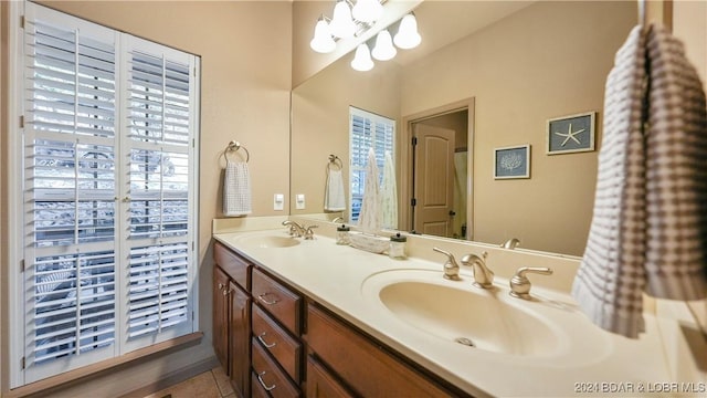 bathroom with tile patterned floors, vanity, and an inviting chandelier