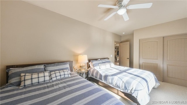 carpeted bedroom with ceiling fan and a closet