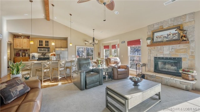 carpeted living room featuring beam ceiling, high vaulted ceiling, ceiling fan, and a stone fireplace