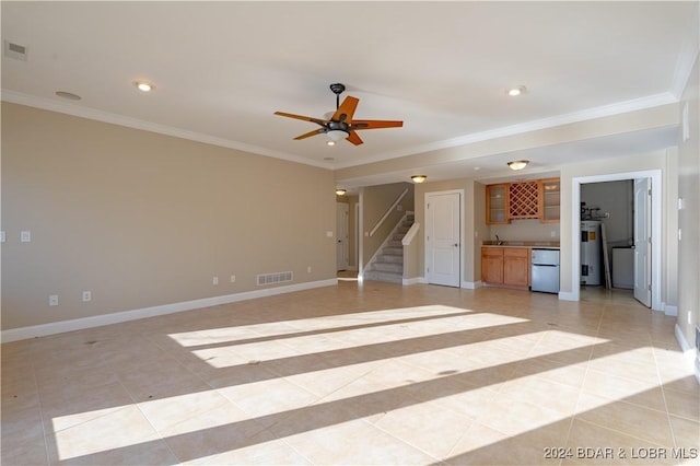 unfurnished living room featuring ceiling fan, water heater, bar, light tile patterned floors, and ornamental molding