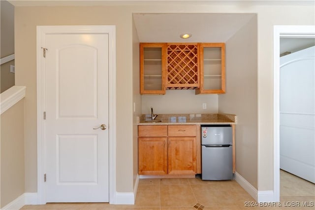 550 Grand Cove Rd, Porto Cima, MO 65079 - indoor wet bar with freestanding refrigerator, baseboards, and light tile patterned floors