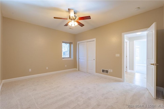 550 Grand Cove Rd, Porto Cima, MO 65079 - unfurnished bedroom with light carpet, baseboards, a closet, and a ceiling fan