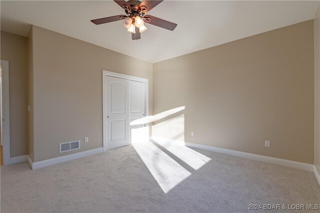 carpeted spare room with ceiling fan