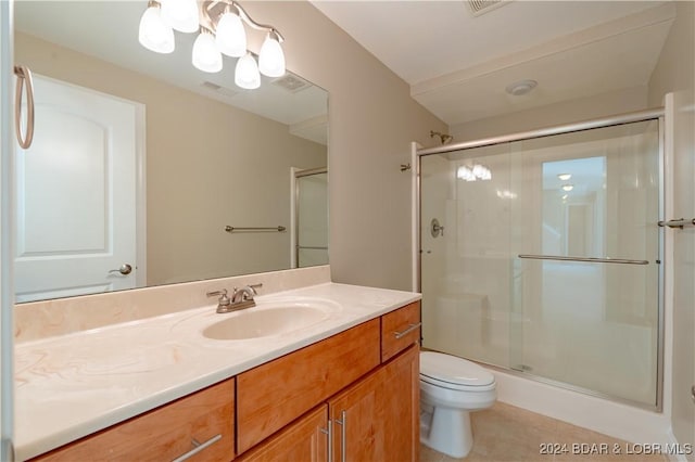 bathroom with tile patterned floors, vanity, toilet, and a shower with door