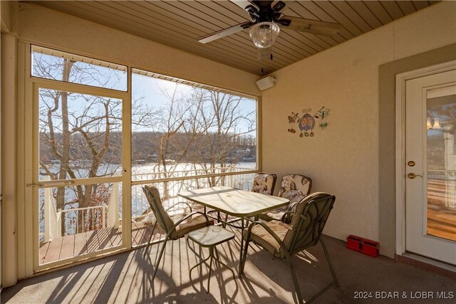 sunroom / solarium featuring ceiling fan, plenty of natural light, and wooden ceiling