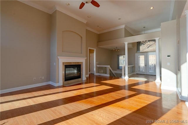 unfurnished living room with ceiling fan, hardwood / wood-style floors, crown molding, and french doors