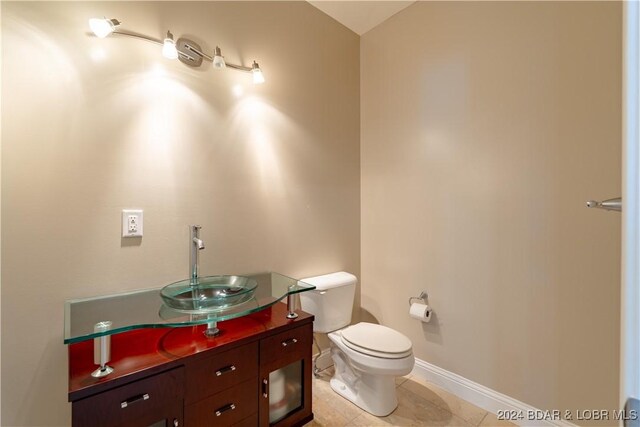 bathroom featuring tile patterned flooring, vanity, and toilet