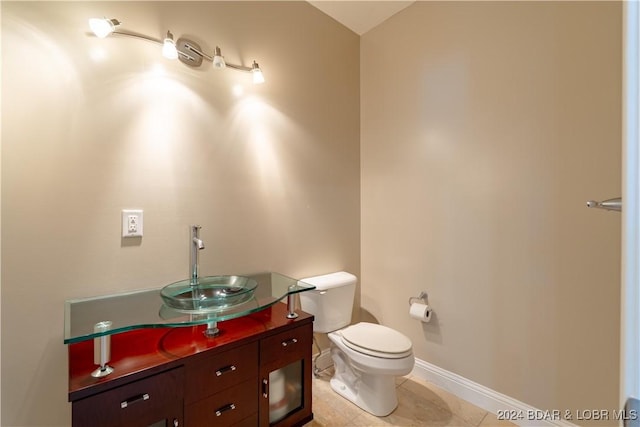bathroom with vanity, toilet, baseboards, and tile patterned flooring