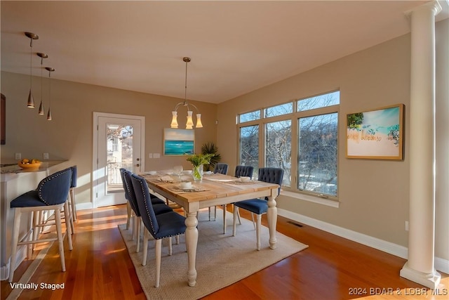 dining space with wood-type flooring and a notable chandelier