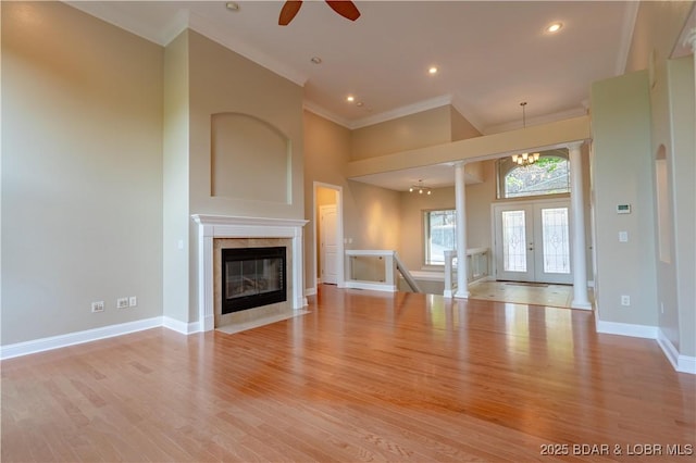 550 Grand Cove Rd, Porto Cima, MO 65079 - unfurnished living room featuring crown molding, wood finished floors, baseboards, ceiling fan, and a chandelier