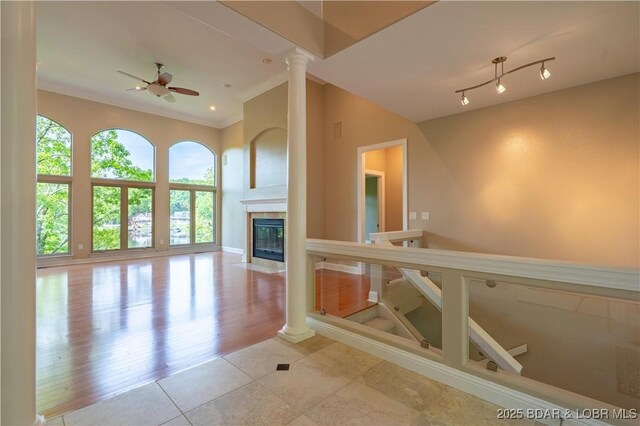550 Grand Cove Rd, Porto Cima, MO 65079 - unfurnished living room featuring a ceiling fan, decorative columns, crown molding, a fireplace, and baseboards