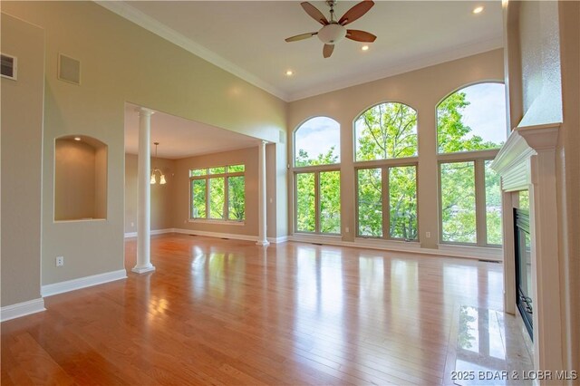 550 Grand Cove Rd, Porto Cima, MO 65079 - unfurnished living room featuring decorative columns, a ceiling fan, light wood-style flooring, baseboards, and a fireplace