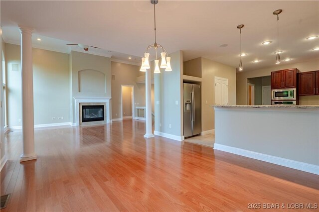 550 Grand Cove Rd, Porto Cima, MO 65079 - unfurnished living room featuring light wood-style floors, ornate columns, baseboards, recessed lighting, and a glass covered fireplace