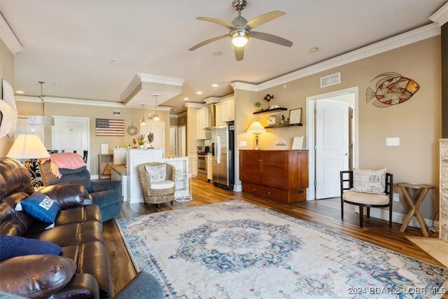 living room featuring ceiling fan, wood-type flooring, and crown molding