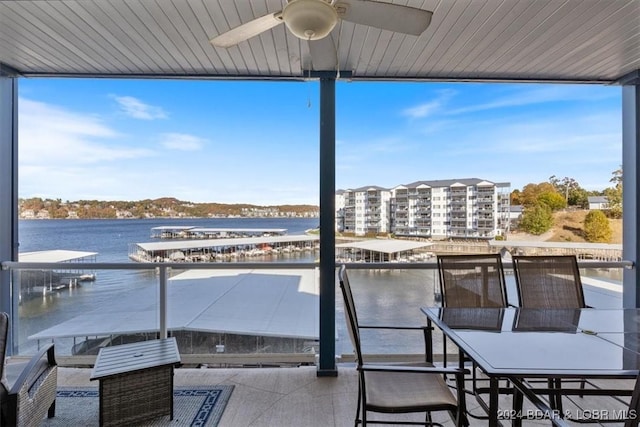 view of patio featuring ceiling fan, a balcony, and a water view