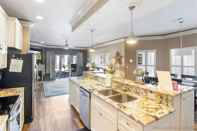 kitchen with sink, hanging light fixtures, stainless steel appliances, dark hardwood / wood-style flooring, and an island with sink