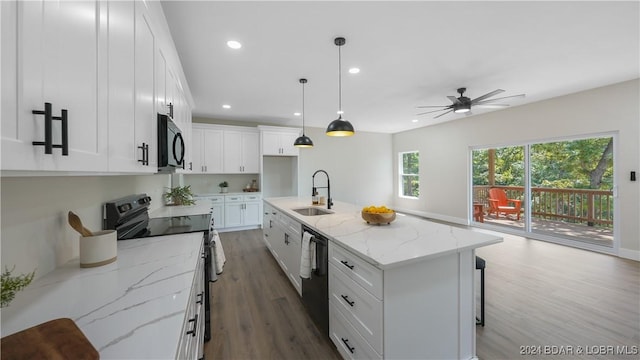 kitchen featuring a kitchen island with sink, black appliances, sink, pendant lighting, and white cabinetry