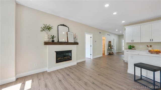 kitchen featuring a kitchen breakfast bar, light hardwood / wood-style flooring, and white cabinetry