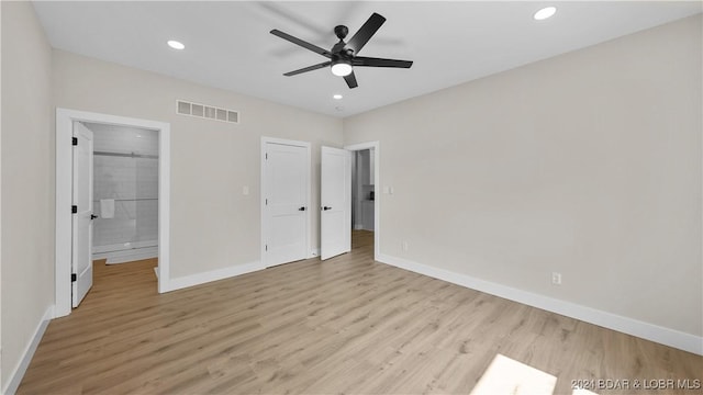 unfurnished bedroom featuring light wood-type flooring, ensuite bathroom, and ceiling fan