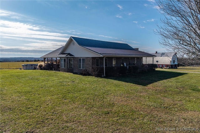 back of property with a yard and a sunroom