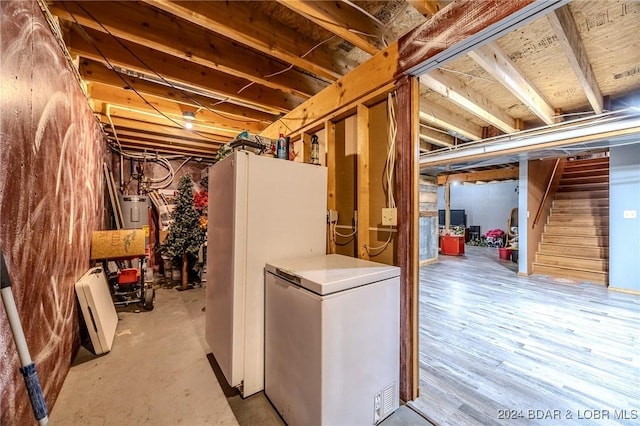 basement featuring white fridge, light hardwood / wood-style floors, and fridge