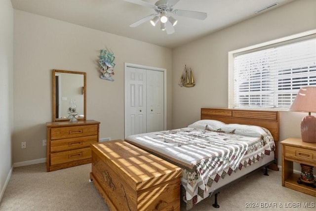 carpeted bedroom with ceiling fan and a closet