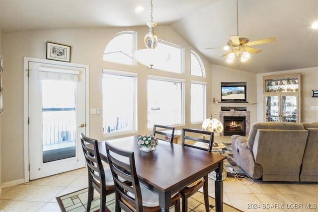 dining area featuring ceiling fan, light tile patterned flooring, a healthy amount of sunlight, and lofted ceiling