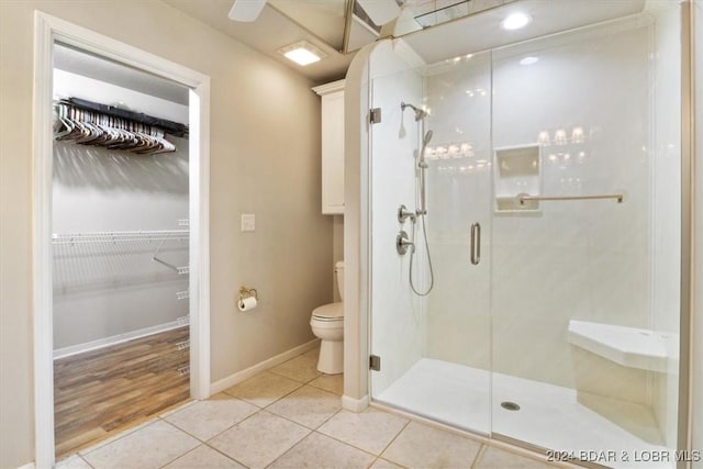 bathroom featuring tile patterned flooring, toilet, and an enclosed shower