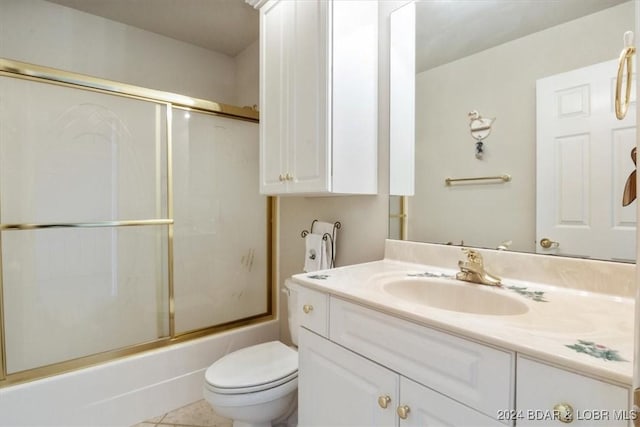 full bathroom featuring combined bath / shower with glass door, vanity, toilet, and tile patterned flooring