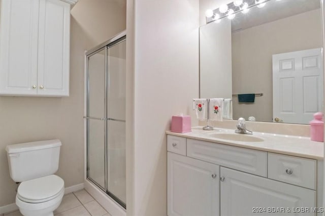 bathroom featuring toilet, vanity, tile patterned floors, and an enclosed shower