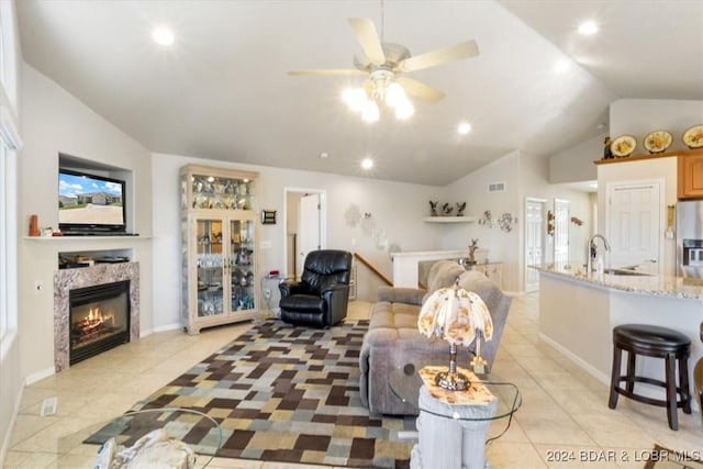 tiled living room featuring vaulted ceiling, ceiling fan, and sink