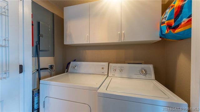 laundry room featuring washer and clothes dryer, cabinets, and electric panel