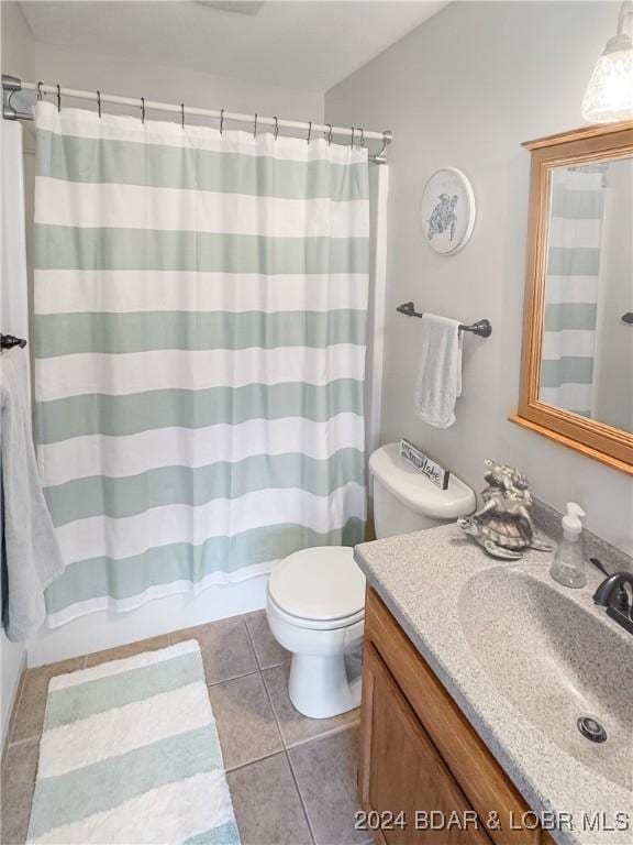 bathroom with tile patterned flooring, vanity, and toilet