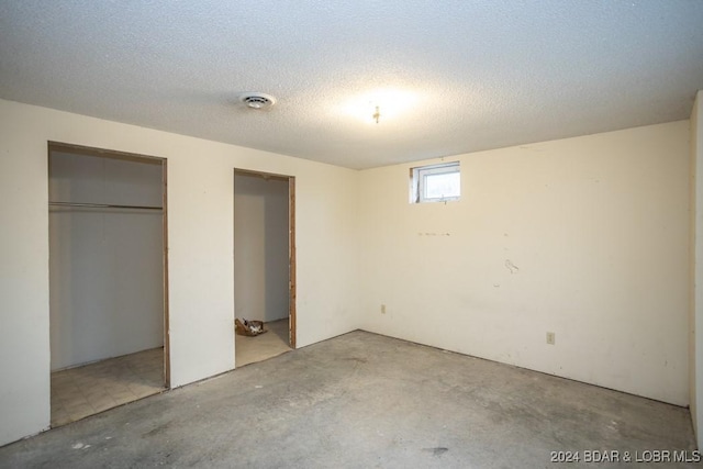 unfurnished bedroom featuring a closet, a textured ceiling, and concrete floors