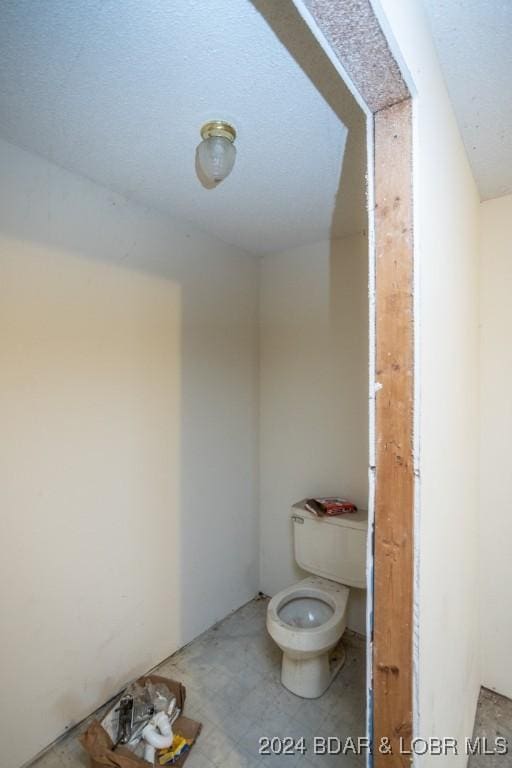 bathroom with toilet and a textured ceiling