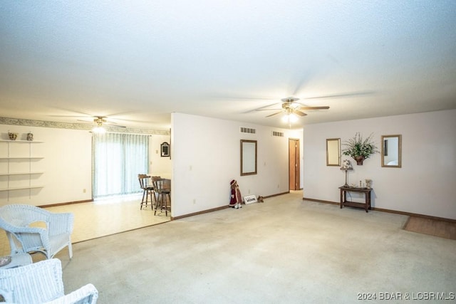 unfurnished living room with ceiling fan and carpet floors