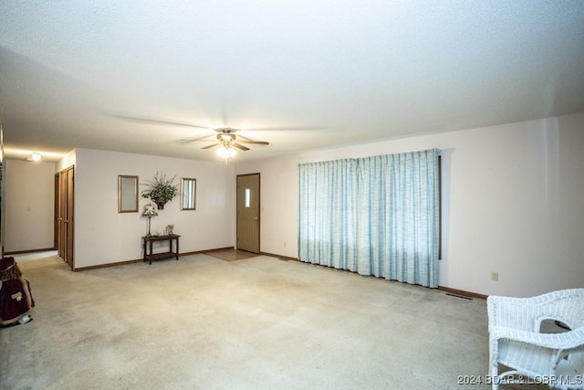 interior space with light colored carpet and ceiling fan