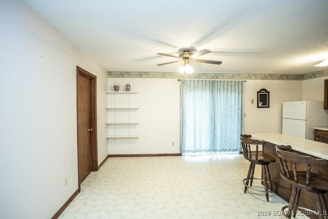 dining space featuring ceiling fan and a textured ceiling