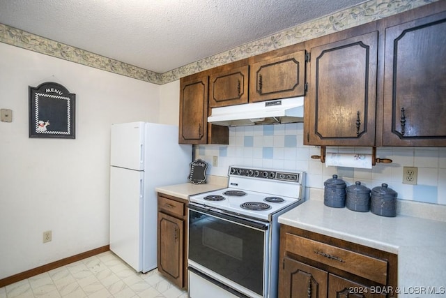 kitchen featuring decorative backsplash, white appliances, and a textured ceiling