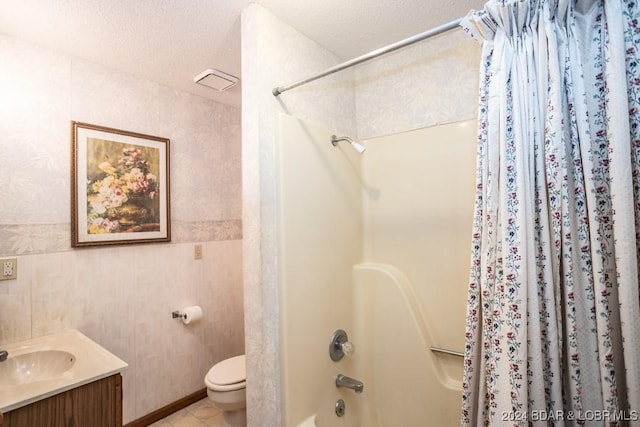 full bathroom with washtub / shower combination, vanity, toilet, tile patterned floors, and a textured ceiling