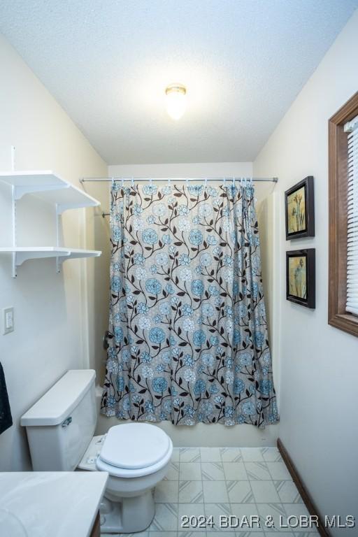 full bathroom featuring shower / tub combo, vanity, and toilet