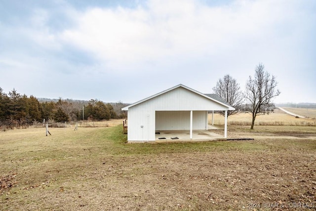 view of outdoor structure with a yard and a rural view