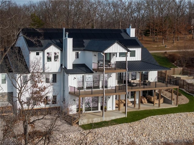 rear view of property featuring a balcony and a patio