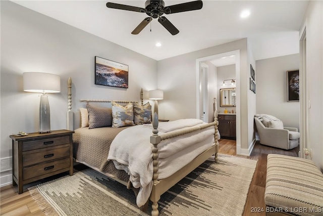 bedroom featuring light wood-type flooring, ensuite bath, and ceiling fan