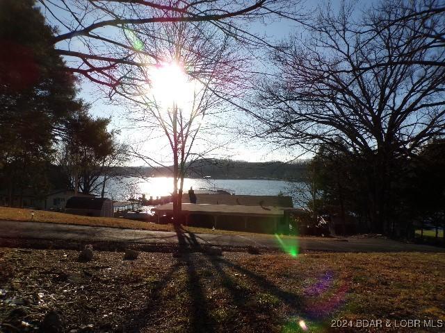 yard at dusk featuring a water view