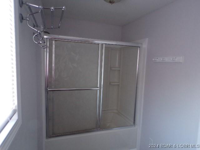 bathroom featuring bath / shower combo with glass door