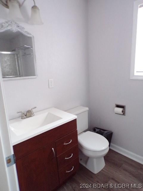 bathroom featuring vanity, hardwood / wood-style flooring, toilet, and walk in shower