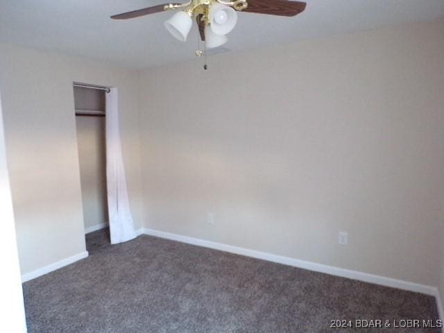 unfurnished bedroom featuring dark colored carpet, ceiling fan, and a closet