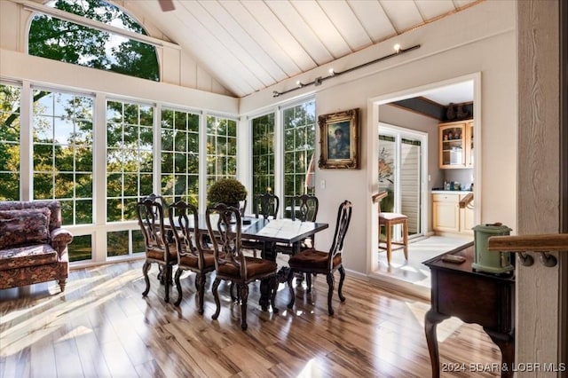 sunroom featuring rail lighting, vaulted ceiling, and wooden ceiling